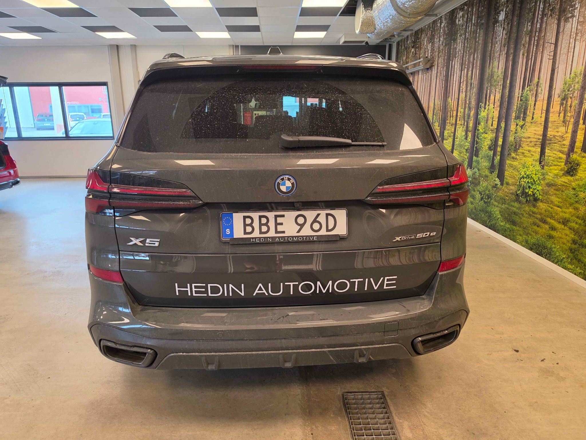 Vit textdekal med Hedin Automotive på bilens baklucka